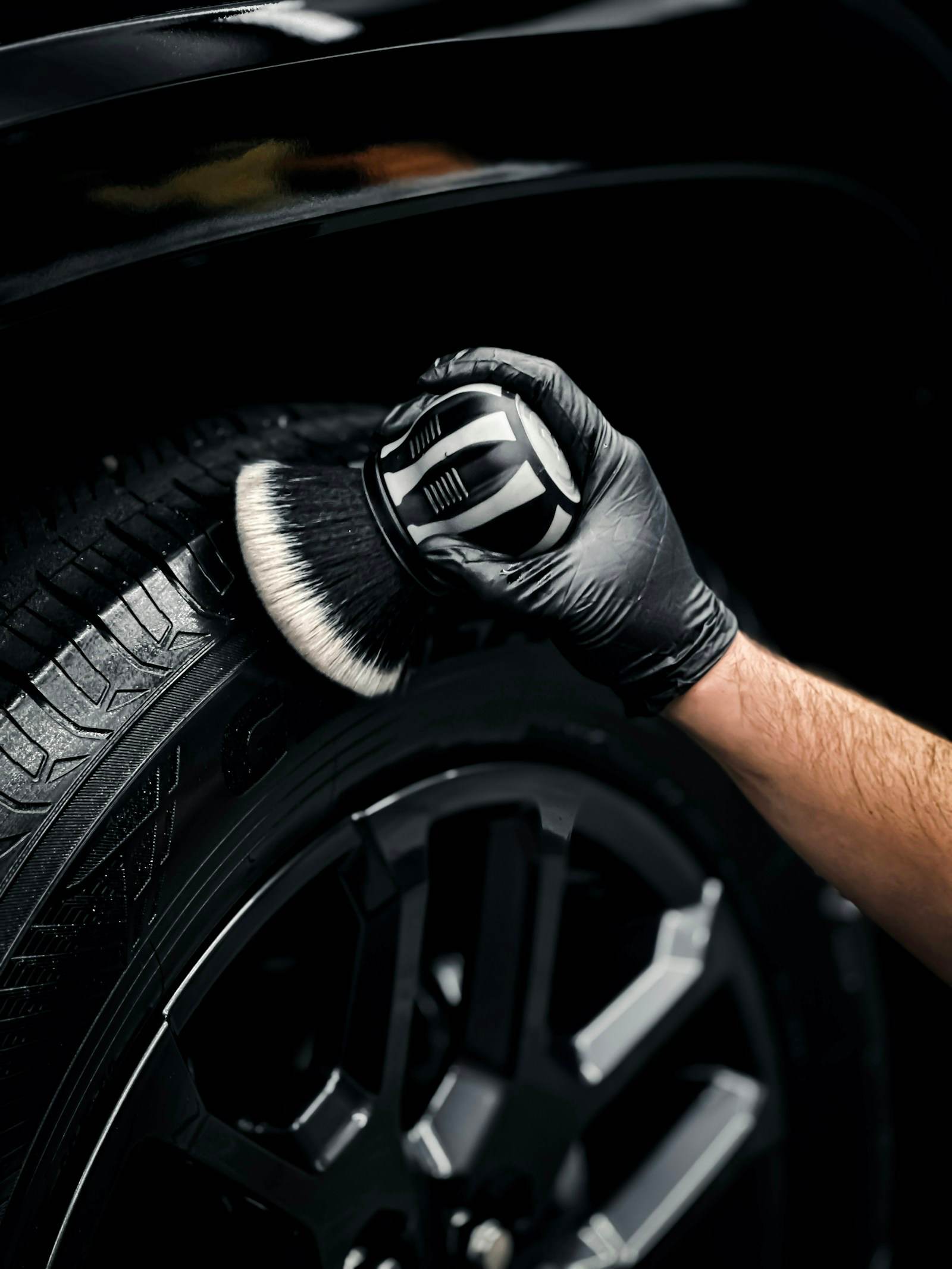Detailer cepillando la goma de una llanta antes de aplicar tire dressing